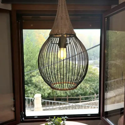 Imagen de la ventana de la casa de Mon Amour con una vistas a la naturaleza y la lámpara de primer plano.