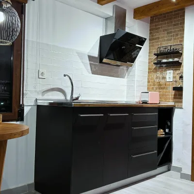 Imagen de la habitación de Mon Amour en la que se muestra la cocina bien equipada con la campana estractora de pantalla.