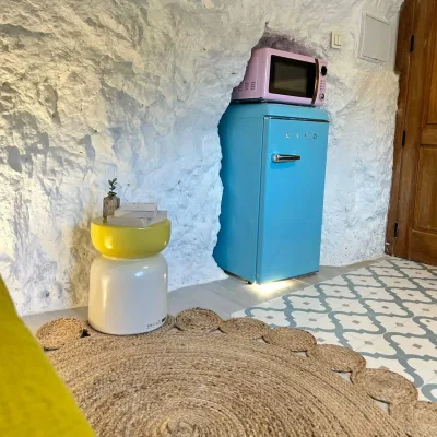 Imagen del frigorífico, el microondas y una mesita en Frida.