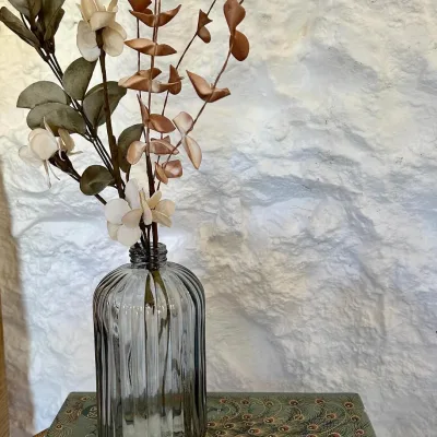 Imagen de un tarro con unas flores decorativas que salen de él.